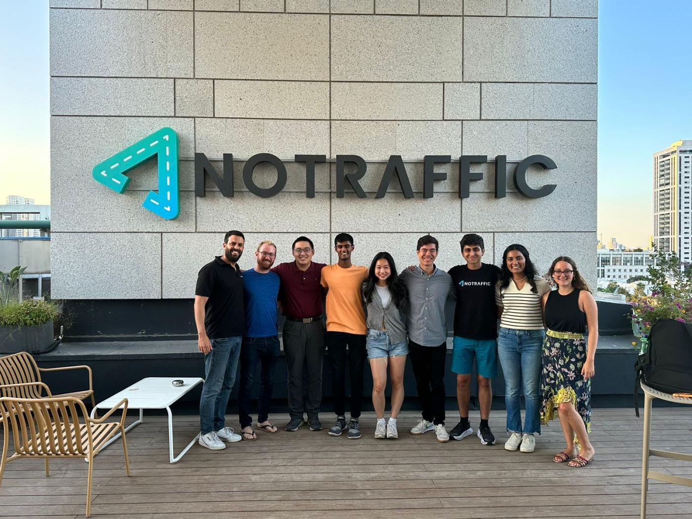 PSIP interns and NoTraffis staff standing outside the NoTraffic building in front of the NoTraffic Sign