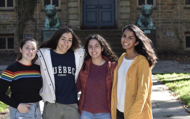Four young college aged women in front of Princeton's Nassau Hall