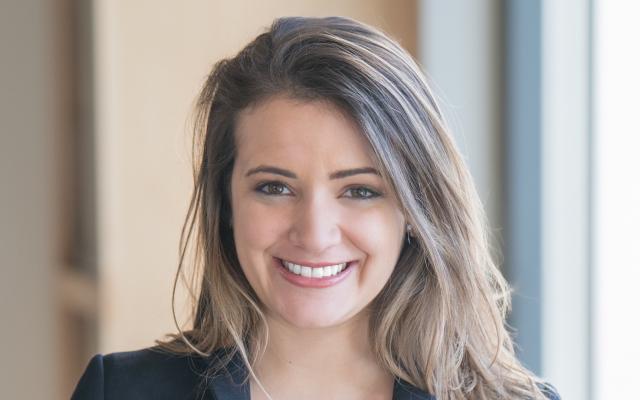 Woman with light brown hair in black blazer 