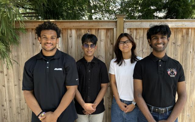 Sekou Roland, Ibraheem Amin, Erika Yeung, Ryan Divan standing outside in front of a fence