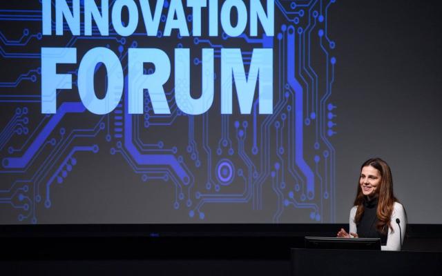 Innovation Forum logo displayed on the screen on the stage of an event.