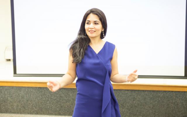 Woman in front of blank white board in blue dress