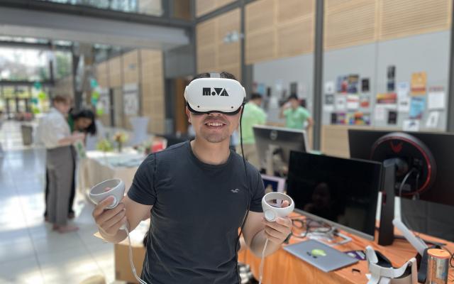 a young man with virtual reality goggles on in a expo setting
