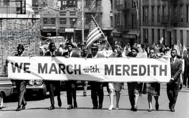 Protesters holding a We March with Meredith banner.