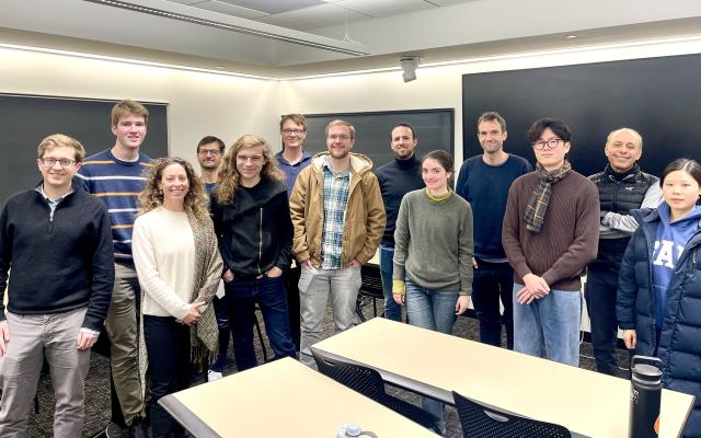 a smiling group of workshop participants standing together in a meeting room