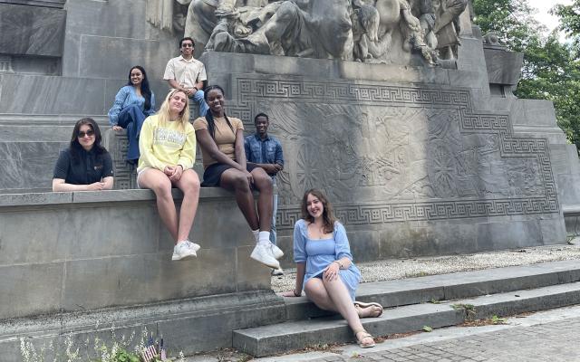 Students sitting by the Princeton Battle Monument outside the Princeton Municipal Building