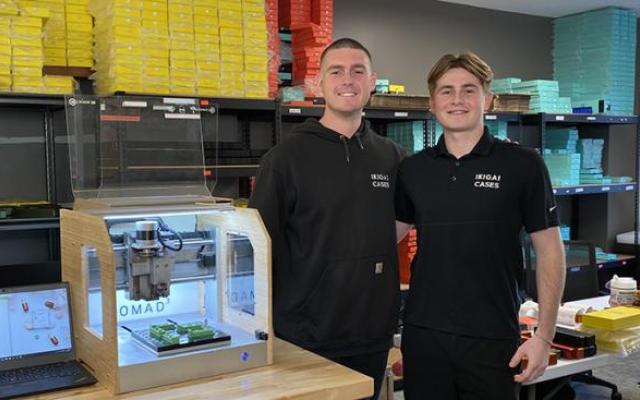 Tavish Rice '20 and his brother Breton standing by a 3D printer