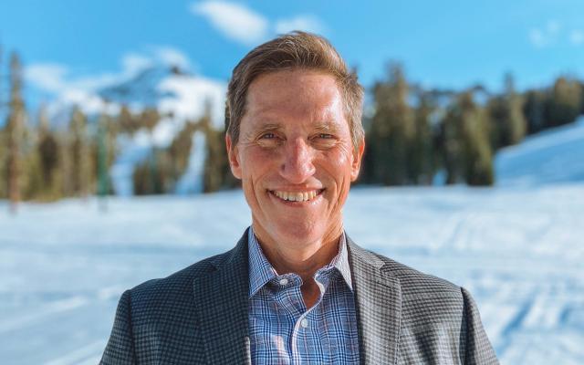 Todd Laurence in gray jacket with woods and snow in background