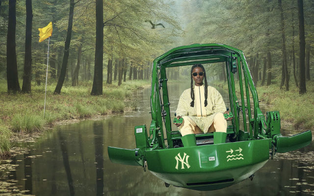 A Black woman piloting a futuristic looking open air hovercraft over a narrow, tree-lined river