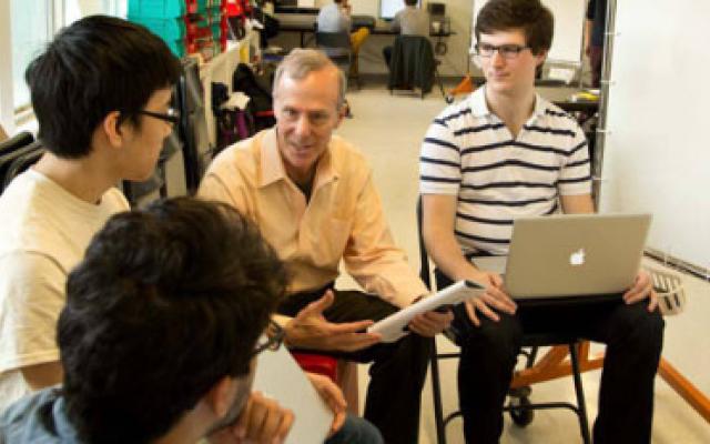 3 students meeting with a professor