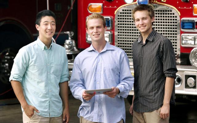 Three men standing in front of a fire truck