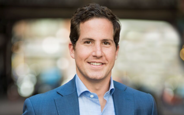 photo of a man in a blue suit and light blue shirt with brown hair