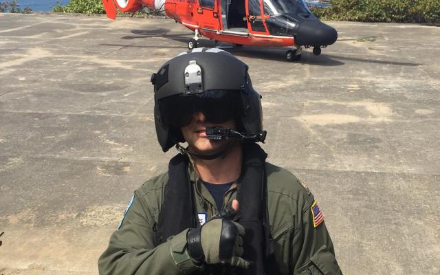 Nick Leiter in military outfit and helmet in front of a red helicopter