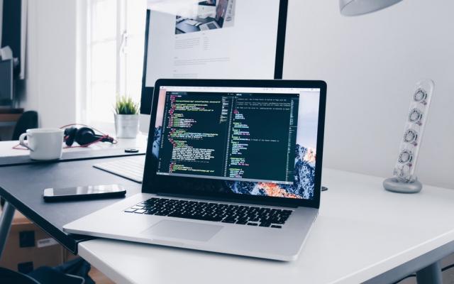 Laptop on desk showing code