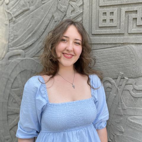 Student smiling in front of monument