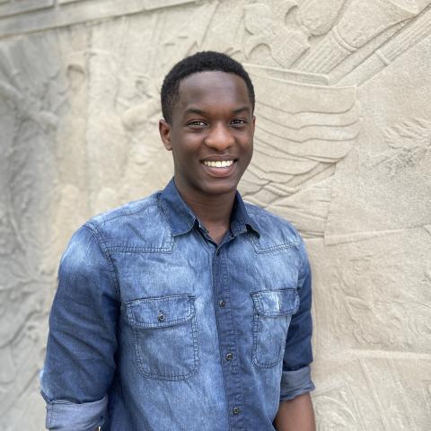 Student smiling in front of monument